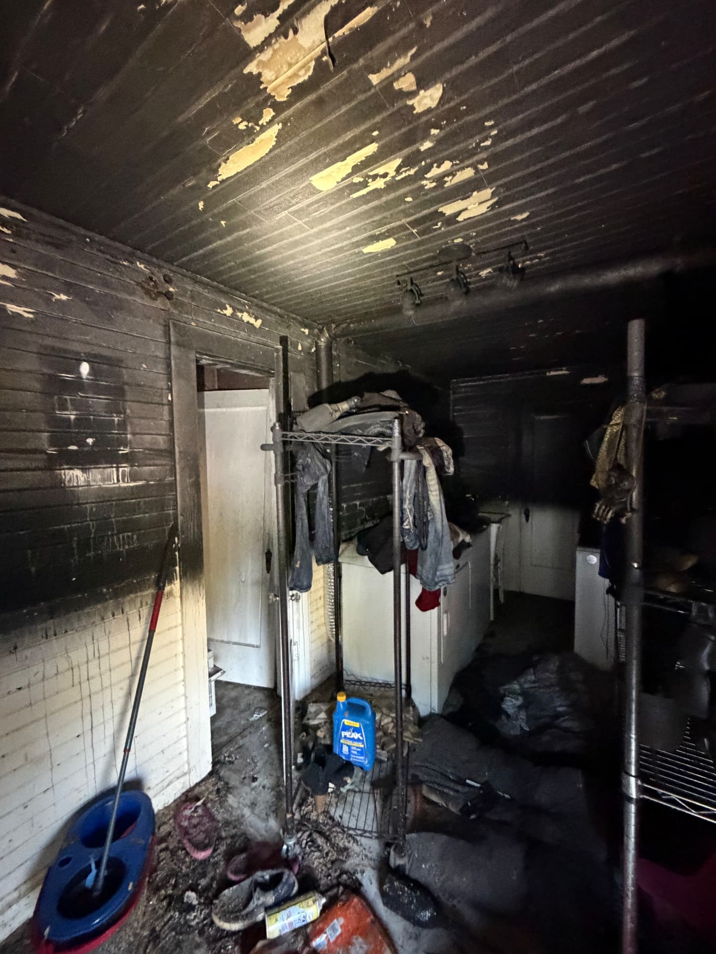 Heavy soot and smoke residue coating the walls, ceiling, and belongings of a home after a fire