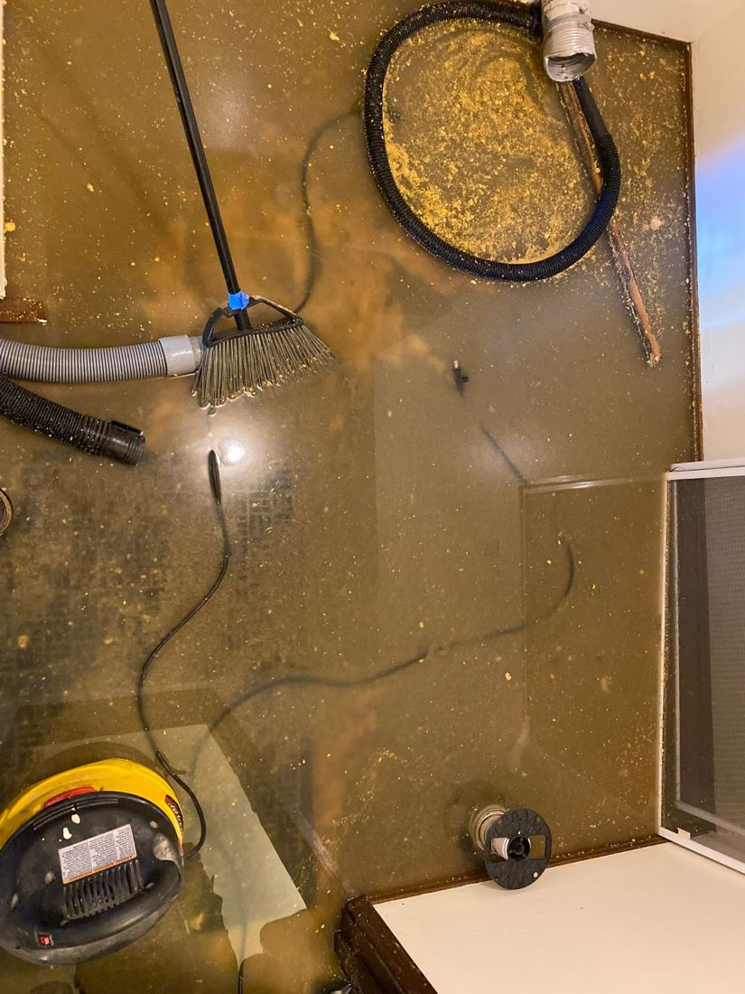 Floor drain area during sewage cleanup with vacuum and broom